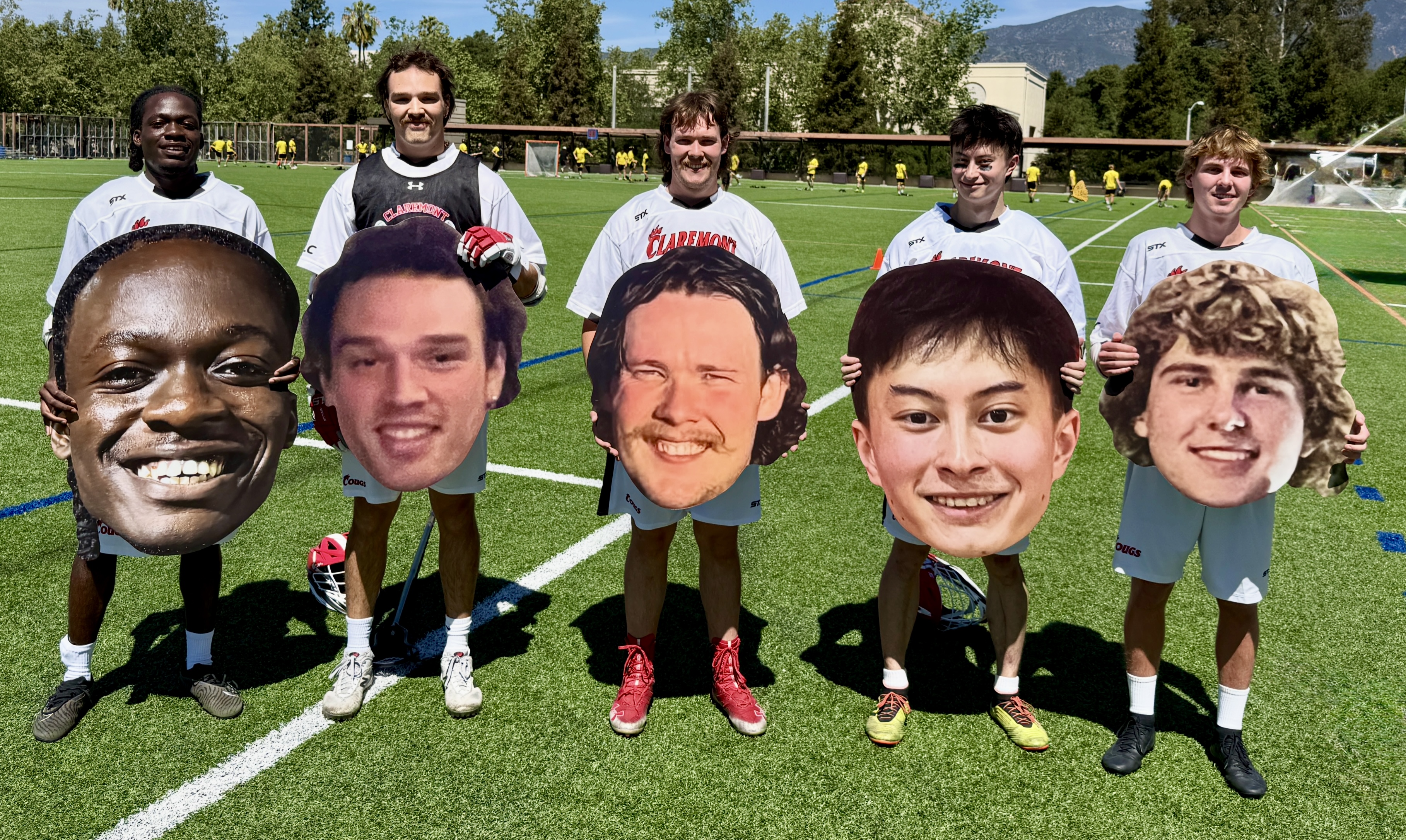 2026 seniors holding big head photos on the field